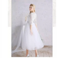 White lace floral wedding dress with three-quarter sleeves, fitted embroidered bodice, and flowing tulle skirt with train