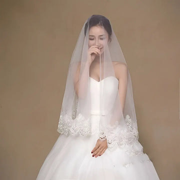 White lace floral bride veil with delicate embroidery along the edge for a white lace floral bridal look