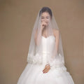 Delicate white lace bride veil with white lace floral embroidery and sheer flowing design for bridal wear