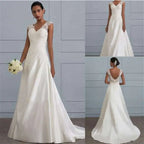 A flowing white lace satin wedding gown with delicate lace shoulders and back featuring a v-neckline and a-line silhouette
