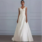 Ivory satin a-line wedding gown with delicate white lace detailing on the shoulders and fitted bodice