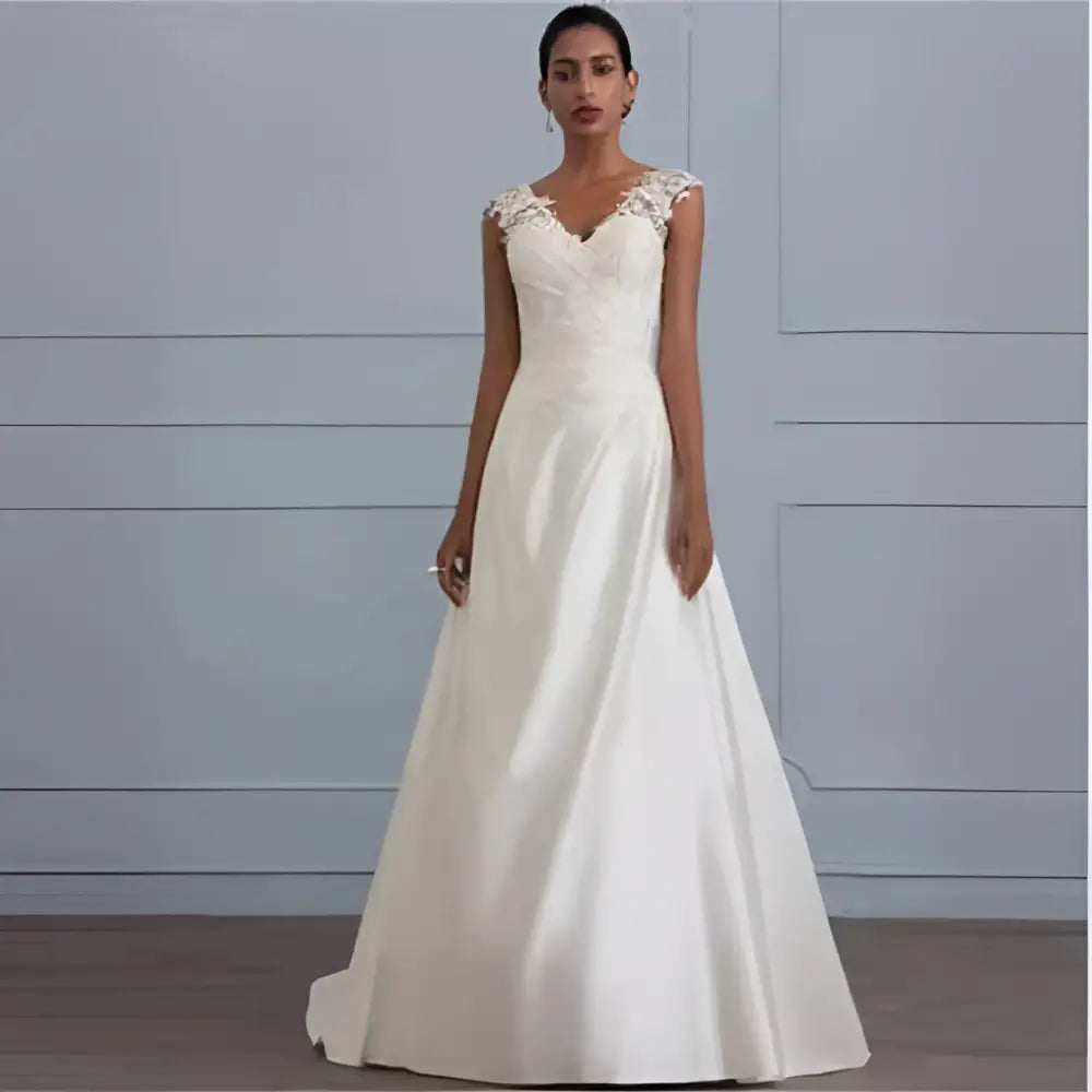 Ivory satin a-line wedding gown with delicate white lace detailing on the shoulders and fitted bodice