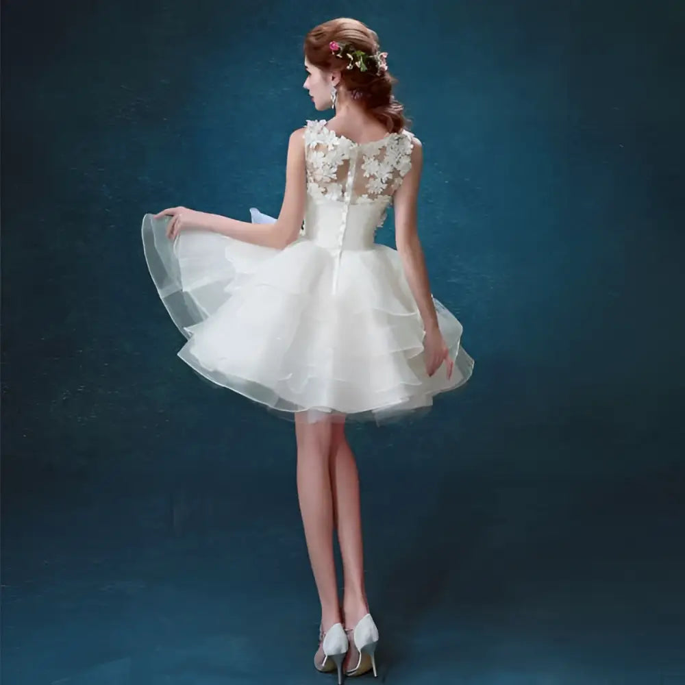 White lace tiered wedding short dress with short sleeves, delicate beading, and a tiered tulle skirt for brides