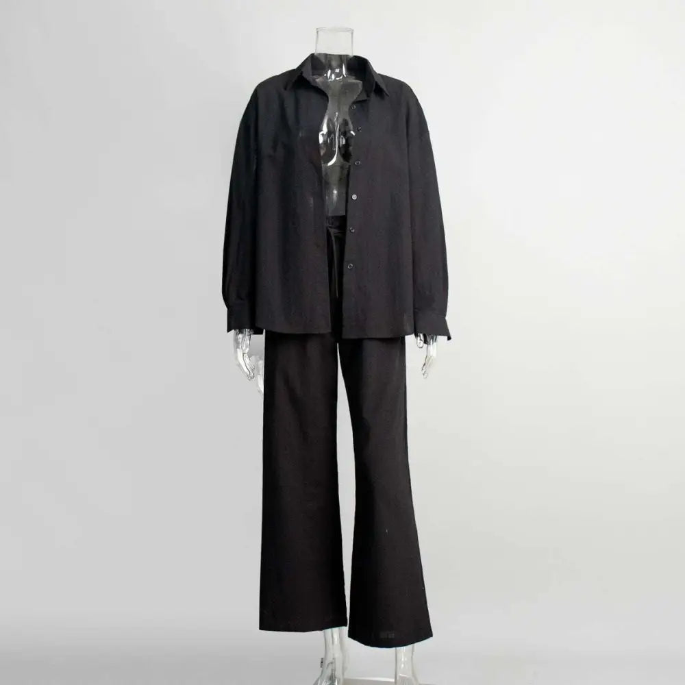 Black oversized shirt trousers suit with relaxed fit and frayed cuffs in contrast to white linen long sleeve shirt trousers suit