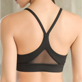 Black sports bra with crisscross back straps and mesh paneling showing fitness racerback bras design features