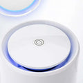 White minimalist usb air purifier with cylindrical design featuring a glowing blue led ring and central power button