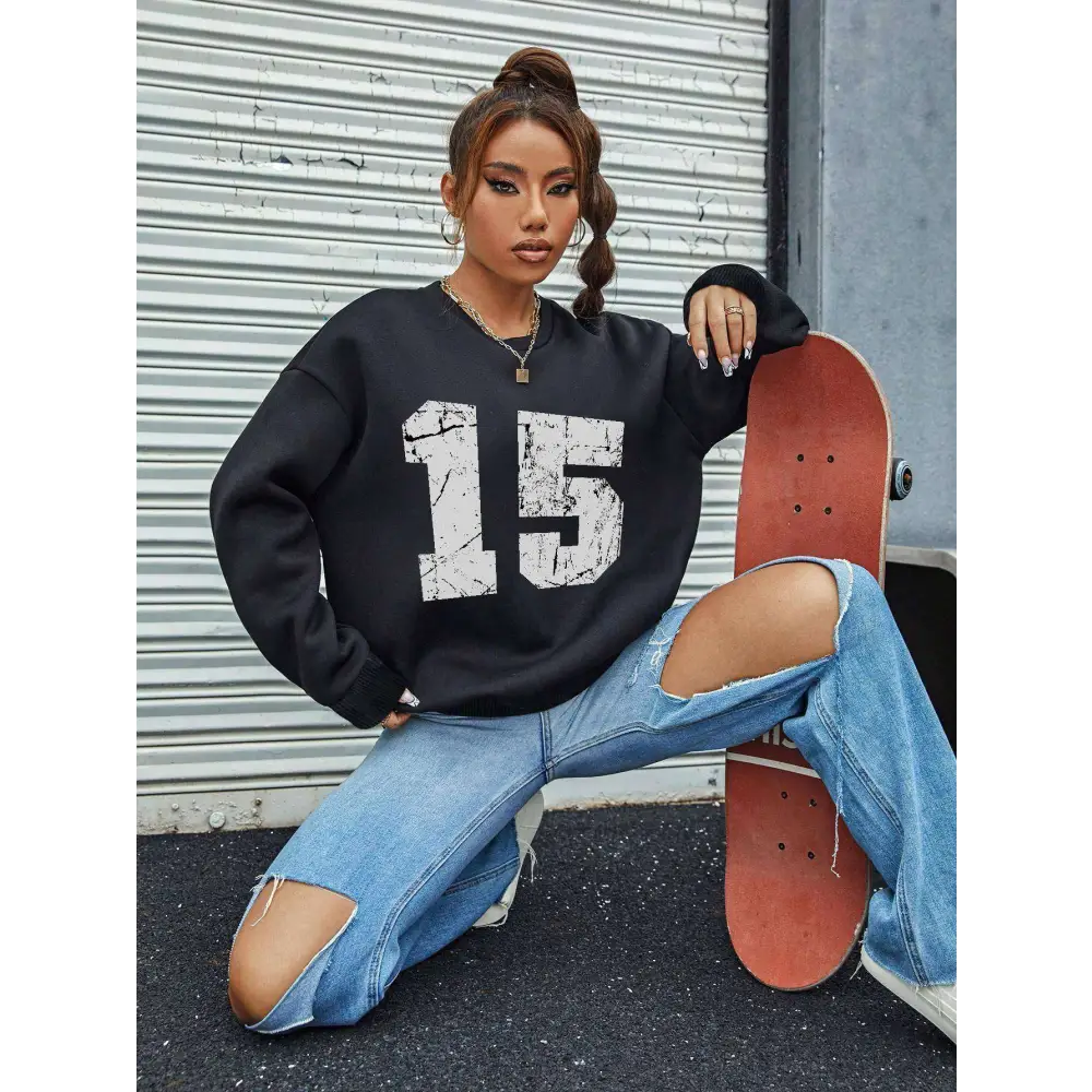 Black distressed graphic crew neck sweatshirt with white 15 print and ribbed knit cuffs and hem