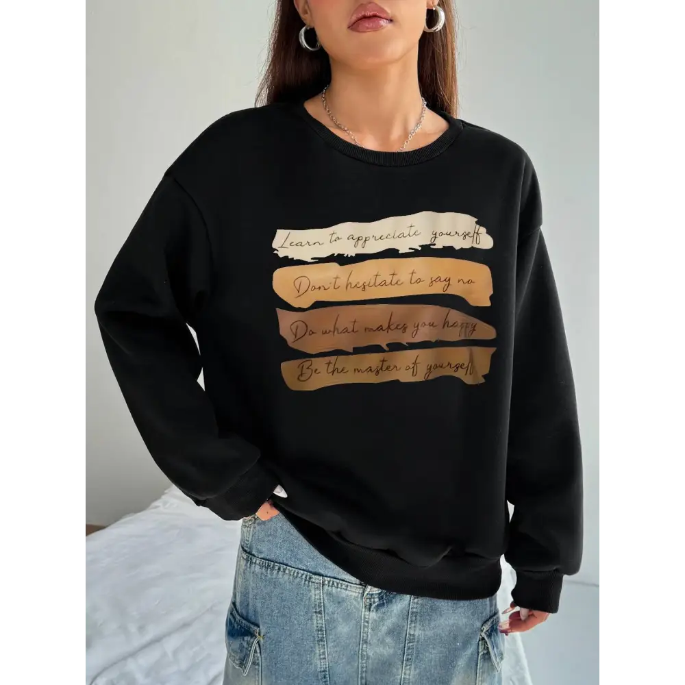 Black oversized long sleeve sweatshirt with motivational quote printed in gold and beige on solid colour horizontal strips