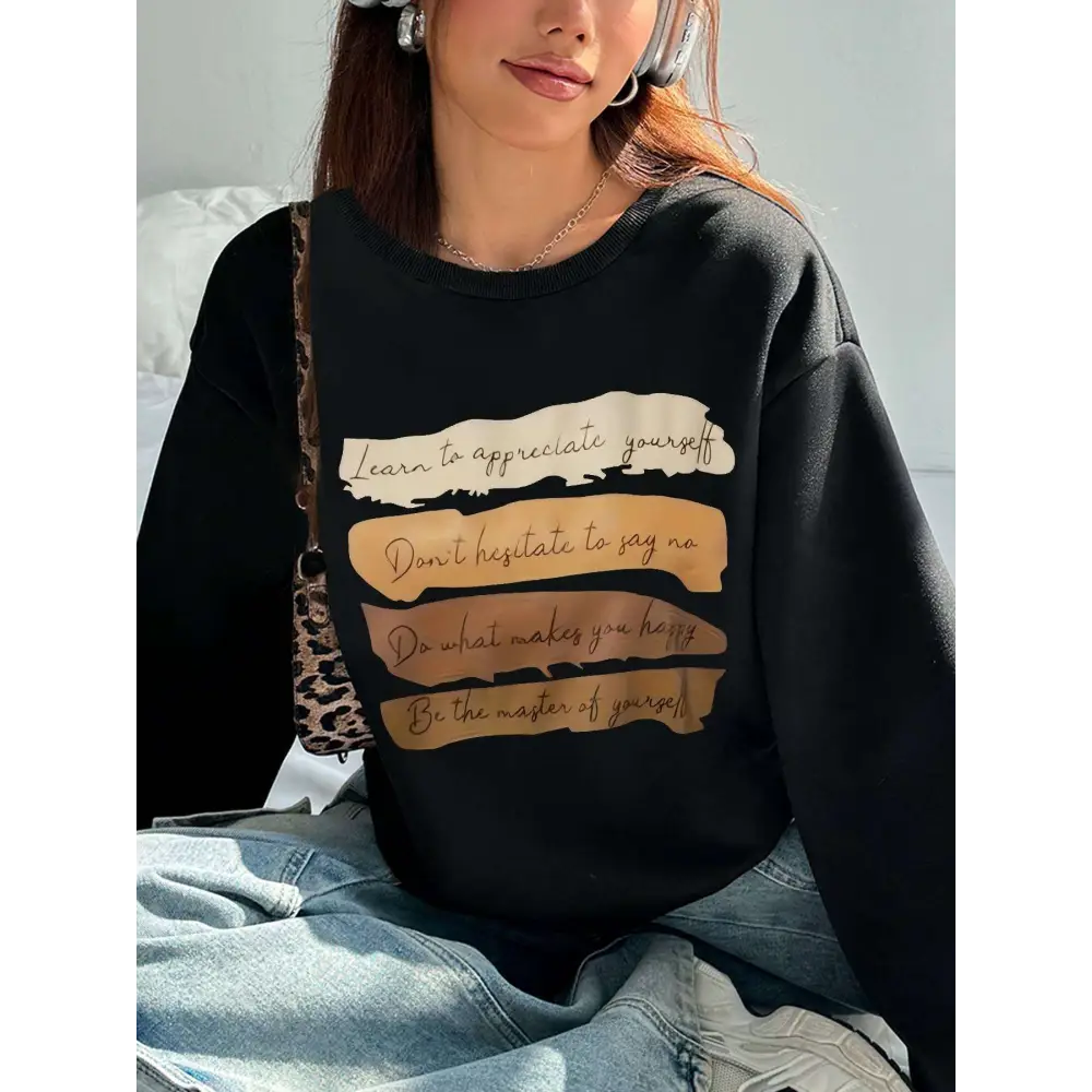Black oversized long sleeve sweatshirt with motivational quote printed in beige and tan brushstroke bands on front