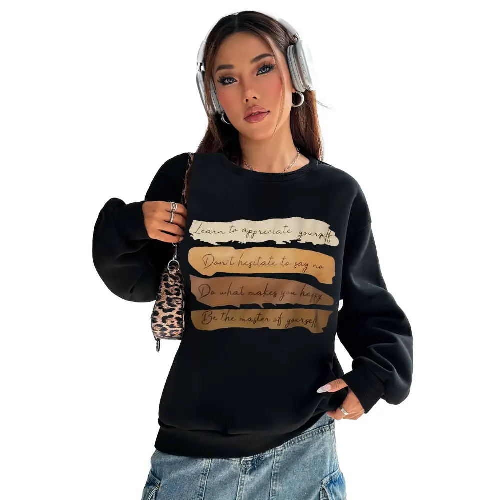 Black oversized long sleeve sweatshirt with motivational quote printed in beige and gold on solid colour stripes