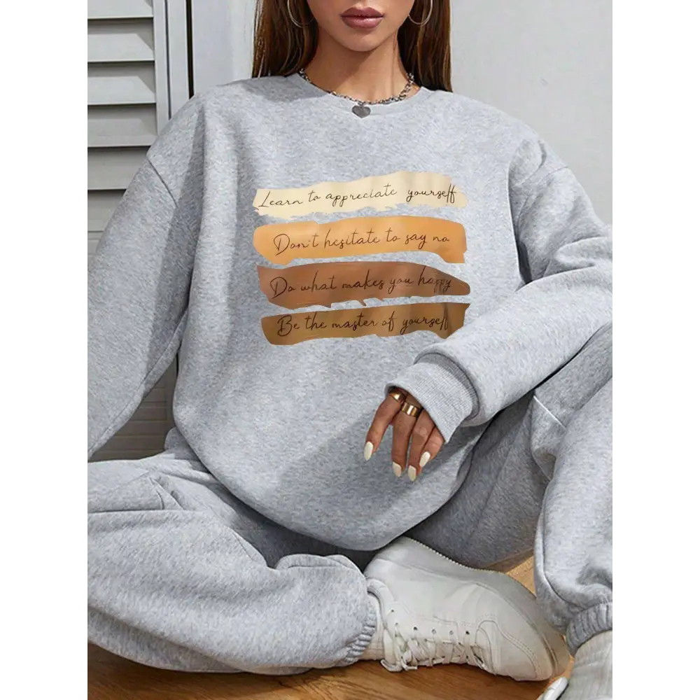 White oversized long sleeve sweatshirt in solid colour with a motivational quote printed in brown and beige on front