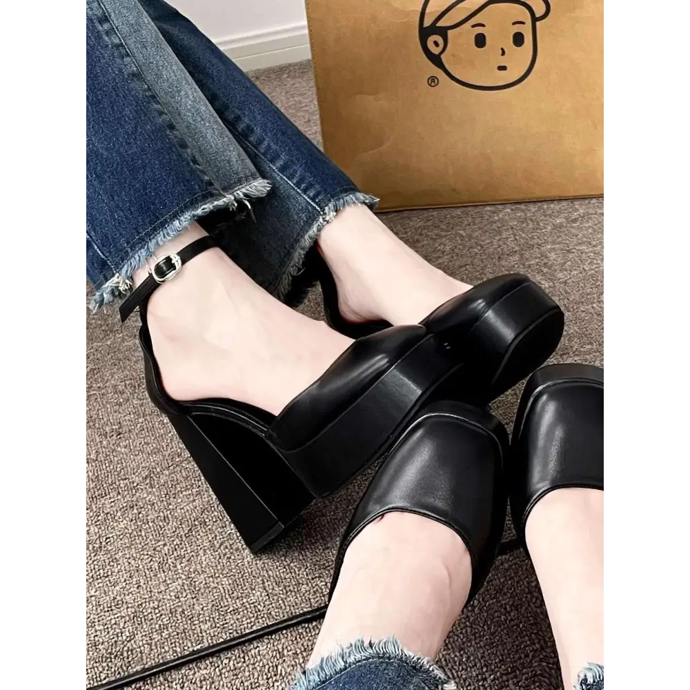 Black platform mary janes with sleek glossy leather finish and ankle strap with silver buckle in super high heel platform style