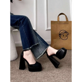 Black platform mary janes with a chunky block heel and ankle strap complement the white patent super high heel platform design