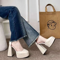 Cream-colored white patent super high heel platform mary janes with thick block heels and sleek minimalist design
