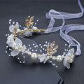 Elegant white pearl and gold children’s wreath adorned with floral headpiece, gold leaf accents, and sheer ribbon details