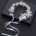 White pearl and gold children’s wreath adorned with sheer fabric flowers, gold butterflies, pearl beads, and flowing ribbon tail