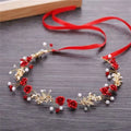 White pearl and gold children’s wreath adorned with red fabric roses, pearls, crystals, and red satin ribbon