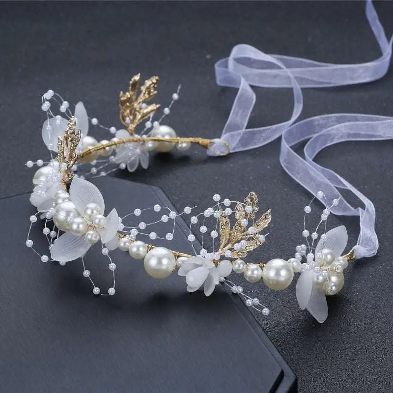 Elegant white flower wreath head adorned with pearls gold leaf accents and sheer ribbon in children’s wreaths