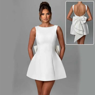 A sleek white satin backless dress summer with pearl embellished neckline and asymmetrical bow flared skirt