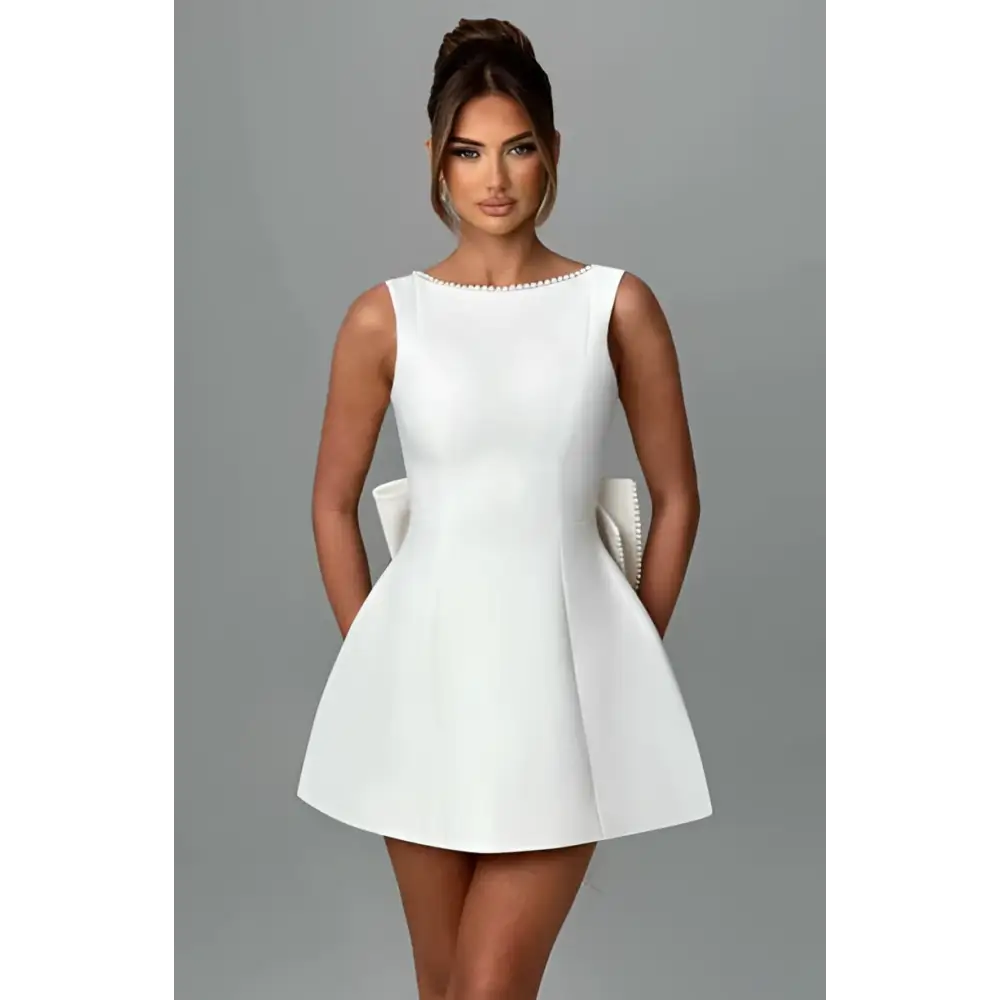 A sleek white satin backless dress summer style with pearl embellished neckline and flared sleeveless mini skirt