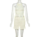 A delicate off-white lace-up flounce skirt two-piece featuring a pleated flounce mini skirt and halter-neck top