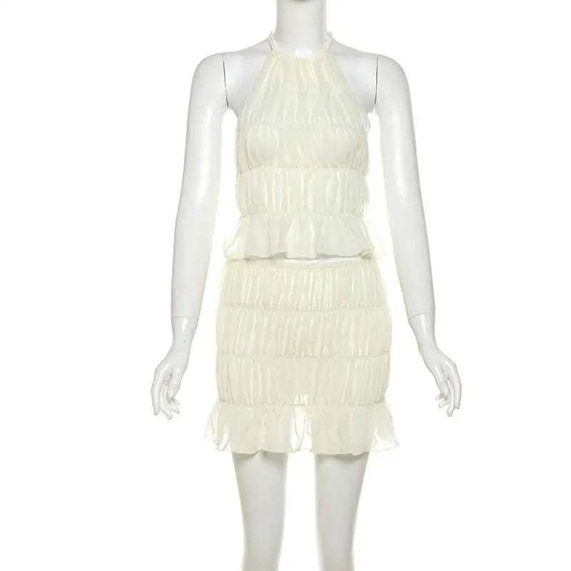 A delicate off-white lace-up flounce skirt two-piece featuring a pleated flounce mini skirt and halter-neck top