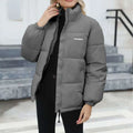 Gray puffer winter coat for women casual windproof wear with high collar and white embroidered branding on chest
