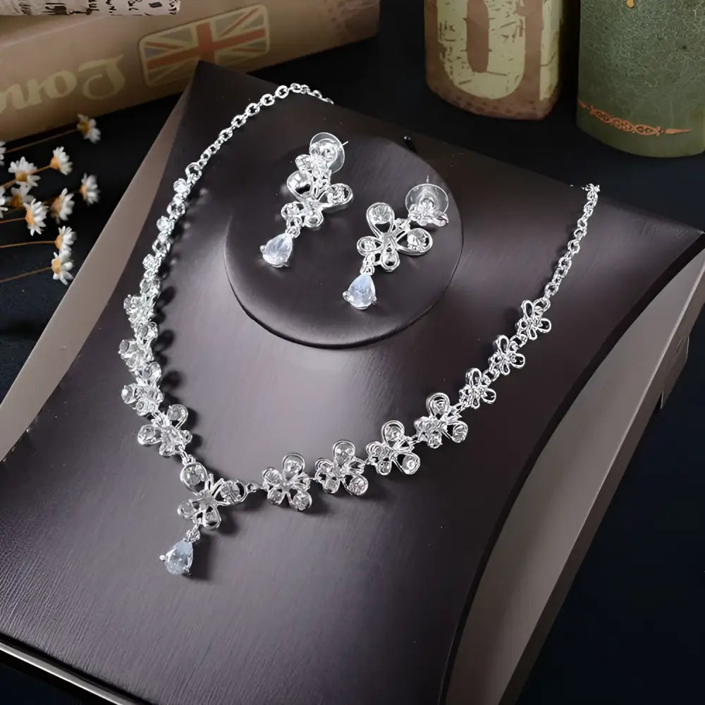 White rhinestone necklace earrings set featuring a silver floral design with crystal accents and teardrop pendants