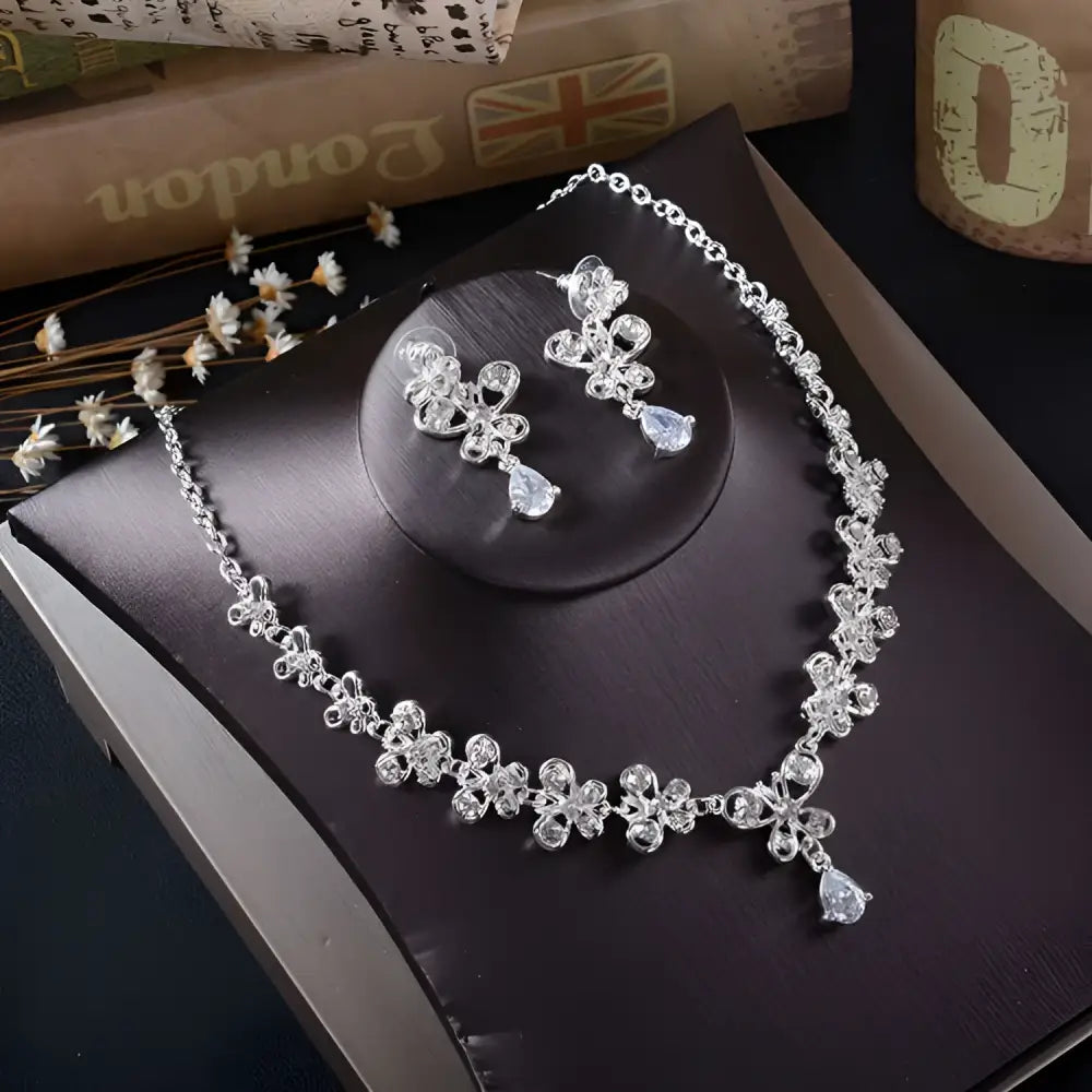 White rhinestone necklace earrings set featuring a silver floral design with crystal accents and teardrop pendants