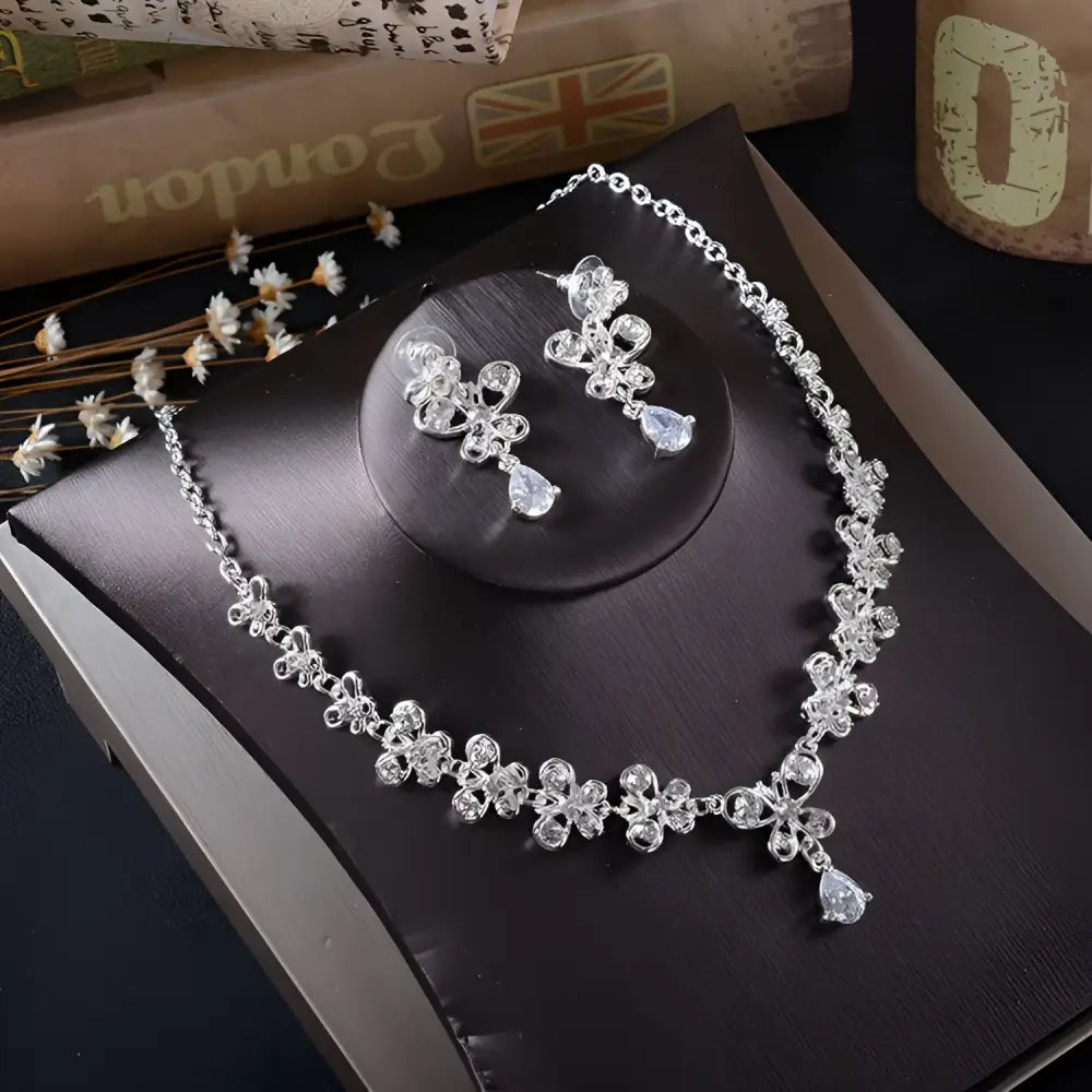 Silver floral white rhinestone necklace earrings set with clear crystal accents and dangling teardrop pendants