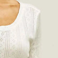 White ribbed knit fashion cardigan with long sleeves featuring delicate lace-like dotted lines and square motifs