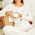 White ceramic mug with vertical ridges and handle complementing a white ribbed knit fashion cardigan long sleeve design