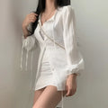 White ribbed long sleeve shirt dress with pleated button-up front and tie cuffs featuring a tie waist detail