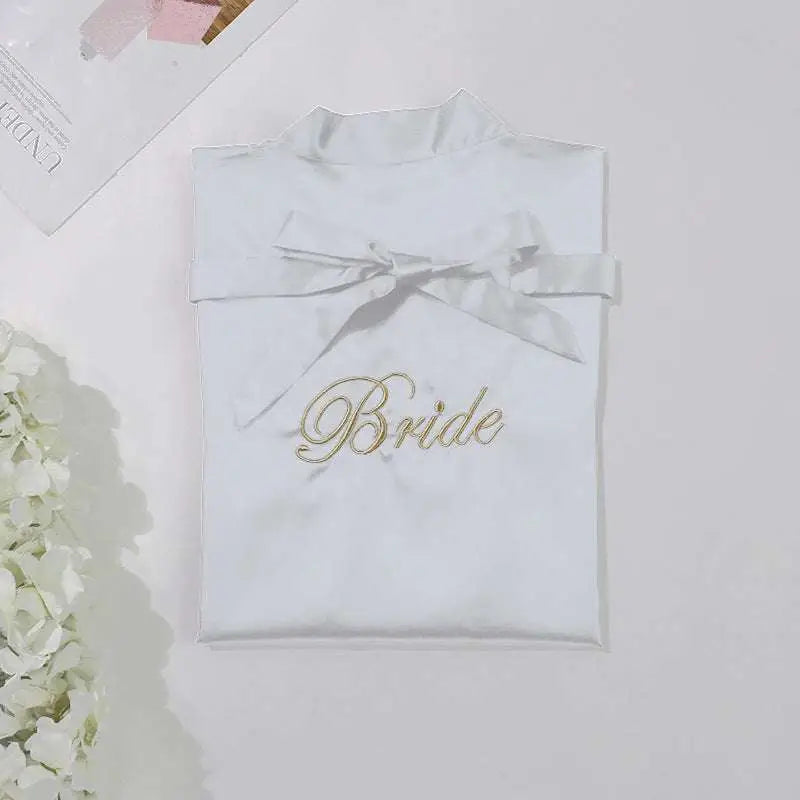 White satin bridal pajamas simulation with gold embroidered bride script and matching satin bow neckline nightgown
