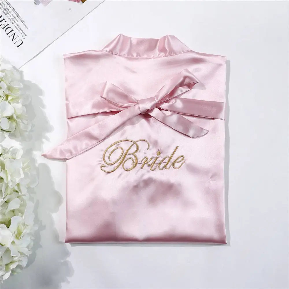 A soft pink satin bridal pajamas simulation silk nightgown with gold embroidered bride and matching ribbon bow