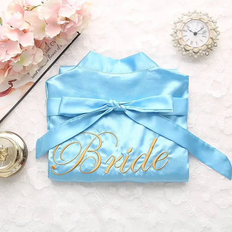 Light blue satin bridal pajamas simulation with gold embroidered bride lettering and matching ribbon tie white satin nightgown