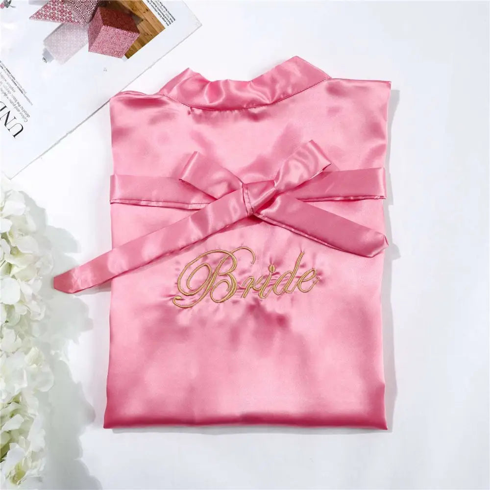 A soft pink white satin bride simulation silk nightgown with matching bow and gold embroidered bride lettering