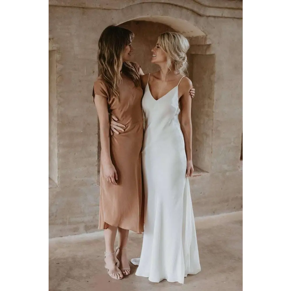White satin evening gown with delicate spaghetti straps and a flowing train brigade for formal occasions