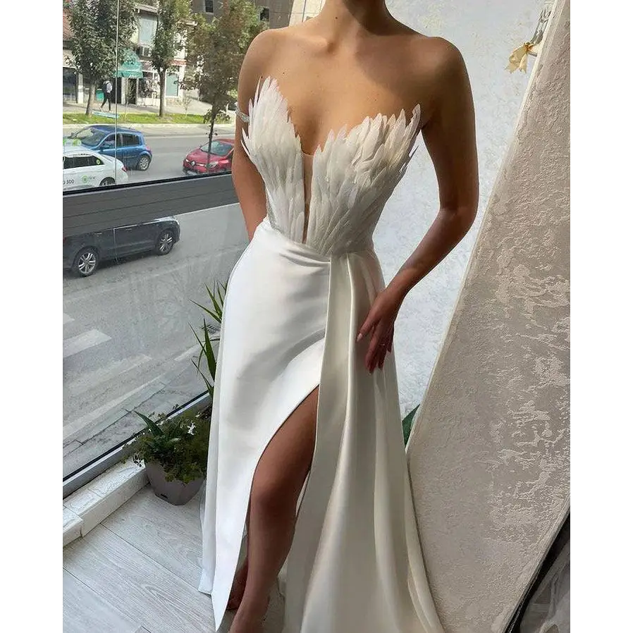 White satin gown with a feathered bodice and high slit designed for plus size dresses sweeping the floor