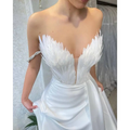 White satin gown with feathered bodice in off the shoulder design and fitted silhouette sweeping the floor