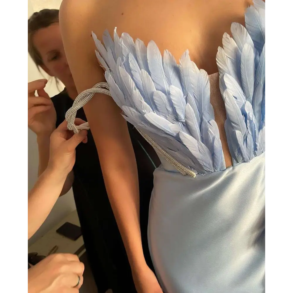 White satin gown with light blue feathered bodice shoulder detail sweeping the floor in plus size dresses collection