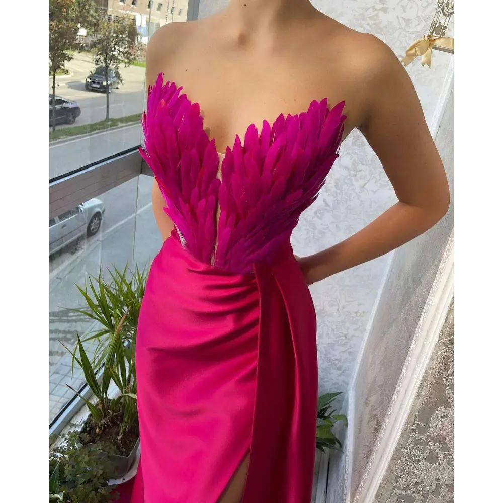 A vibrant fuchsia strapless gown featuring a feathered bodice and satin skirt suitable for plus size dresses
