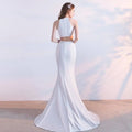 White satin halter neck evening dress featuring a sleek mermaid-style two-piece design with fitted skirt length