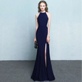 A sleek navy blue halter neck evening dress with a high slit and flowing silhouette showcasing skirt length