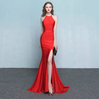 A striking red satin mermaid gown with high neckline and thigh-high slit complementing white satin halter neck evening dress