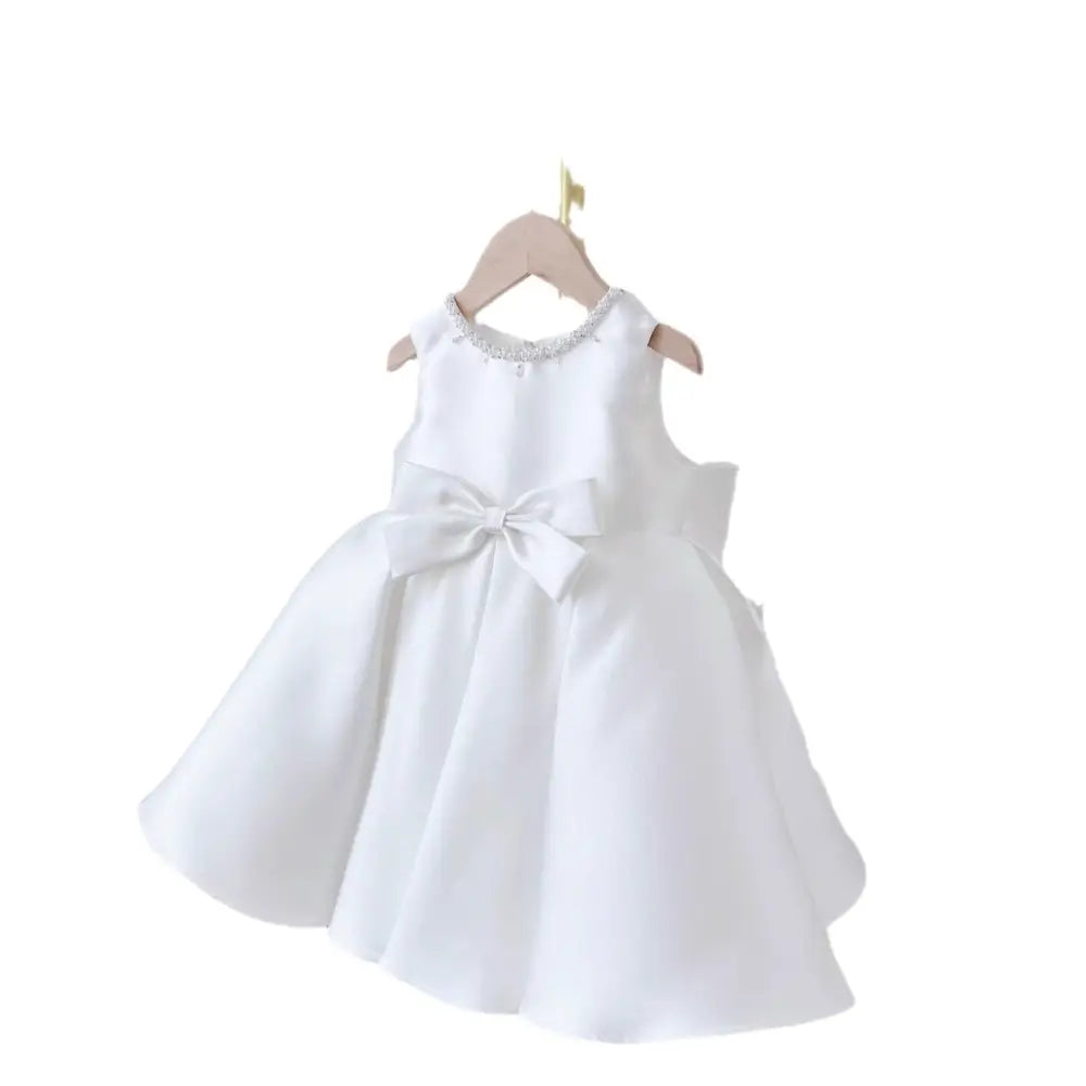 White satin long sleeve baby dress white classic style with beaded neckline and large bow at the waist