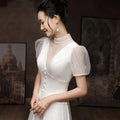White satin engagement wedding dress with high neckline, sheer puff sleeves with polka dots, and front button closure