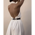 White sexy sleeveless halter backless jumpsuit featuring a high collar and black belt viewed from the back side