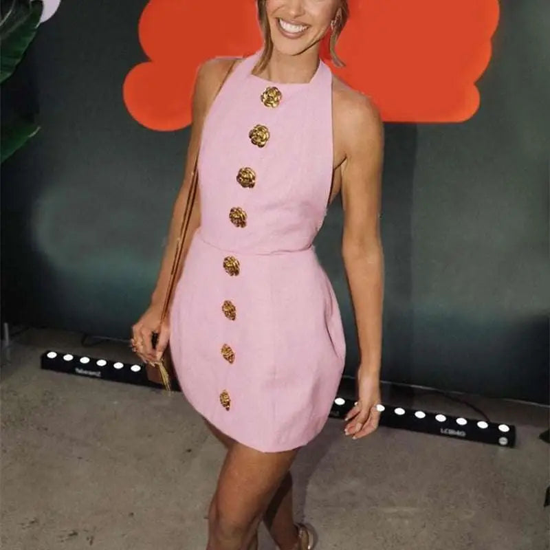 Pink halter-neck mini dress with gold rose button design down the front, sleeveless backless dress style