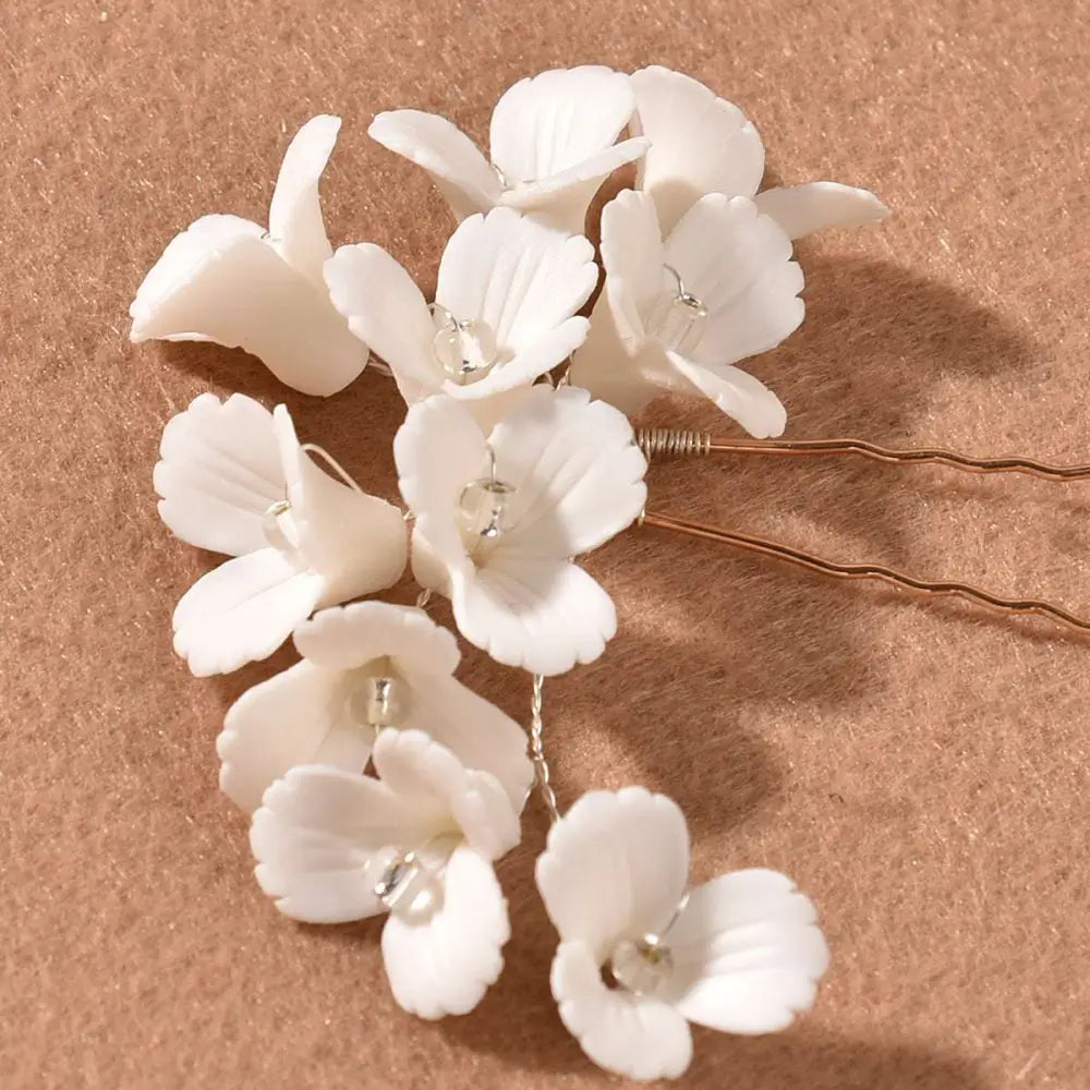 White three dimensional flower u shaped hairpin with white ceramic petals and clear crystal centers with twisted metal pins